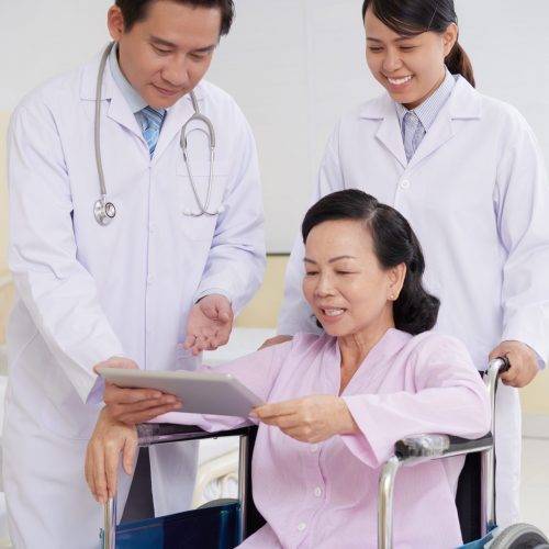 Cheerful aged woman reading doctors presctiption on digital tablet